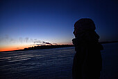 Junge Frau beim Spaziergang auf dem zugefrorenen Wasser des Bottnischen Meerbusens, Kemi, Lappland