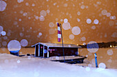 Holzhäuschen am Inari-See im Winter, Lappland, Finnland