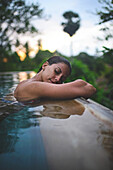 Young attractive woman enjoying a bath in the infinity edge swimming pool at The Dutch House, Galle, Sri Lanka