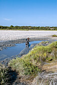 People enjoy a mud bath in Espalmador, a small island located in the North of Formentera, Balearic Islands, Spain
