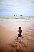 Young boy playing on the beach shore, Hikkaduwa, Sri Lanka
