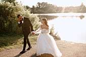 Bride and groom walking on lakeshore