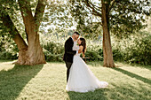 Braut und Bräutigam umarmen sich im Park