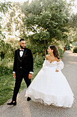 Bride and groom walking in park