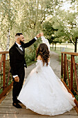 Braut und Bräutigam auf einem Steg im Park