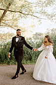 Braut und Bräutigam gehen im Park spazieren