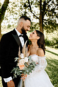 Smiling bride and groom in park