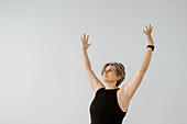 Studio shot of woman with arms raised