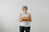 Portrait of smiling woman holding yoga block