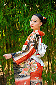Porträt einer Kimono tragenden Frau im Park