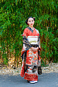 Porträt einer Kimono tragenden Frau im Park