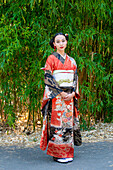 Portrait of woman wearing kimono standing in park