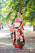 Woman in kimono posing in park