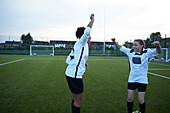 UK, Weibliche Fußballspielerinnen (10-11, 12-13) jubeln auf einem Feld