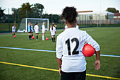 UK, Mädchenfußballmannschaft (10-11, 12-13) beim Training auf einem Feld