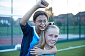 UK, Lächelnde Fußballspielerinnen (10-11, 12-13) auf einem Feld