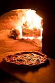 Pizza in oven with fire