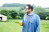 Man with mug standing in field