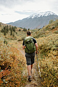 Kanada, Yukon, Whitehorse, Rückansicht eines Mannes beim Wandern in einer Berglandschaft