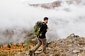 Canada, Whitehorse, Man with backpack hiking in rocky landscape