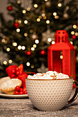 Hot chocolate with marshmallows in front of Christmas tree