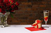 Herzförmiger Geschenkkarton und Valentinstagsdekoration auf dem Tisch