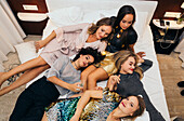 High angle view of five young women on bed