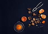Tangerine and nuts on black background