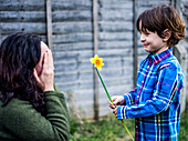 Boy giving mother flower