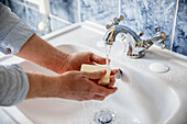 UK, London, Close-up of man washing hands in bathroom