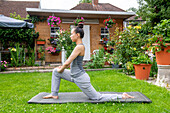 UK, London, Frau trainiert auf dem Rasen vor dem Haus