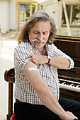 Austria, Portrait of pianist with adhesive bandage on arm