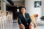 Italy, Portrait of businesswoman sitting in creative studio