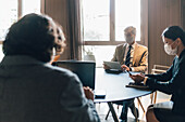 Italy, Business people in face masks having meeting in office