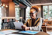 Italy, Smiling businesswoman using digital tablet in creative studio