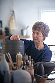 Spain, Baleares, Woman making ceramics in workshop