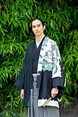 UK, Portrait of young man wearing kimono in park