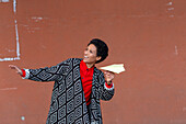 Italien, Toskana, Pistoia, Lächelnde Frau mit Papierflugzeug