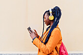 Italy, Milan, Woman with headphones and smart phone outdoors