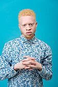 Studio-Porträt eines Albino-Mannes in blau gemustertem Hemd