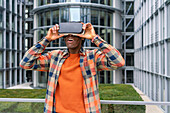 Germany, Berlin, Man using virtual reality goggles in city