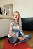 Österreich, Wien, Ältere Frau mit Pflasterverband am Arm auf Yogamatte sitzend