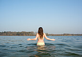 Niederlande, Noord-Brabant, Breda, Rückansicht einer Frau, die in einem See spazieren geht