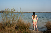 Netherlands, Noord-Brabant, Breda, Rear view of woman walking into lake