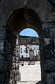 Alter Stadtplatz durch einen Steinbogen gesehen, Sizilien, Italien