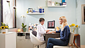 Beautician talking to patient at desk