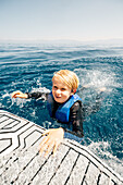 Junge (12-13) schwimmt im See
