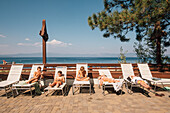 Children (6-7, 8-9, 12-13) sunbathing on sun loungers