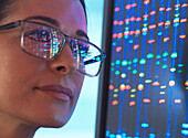 Nahaufnahme eines Wissenschaftlers mit DNA-Sequenzierung, der sich in einer Brille spiegelt