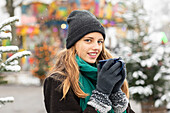 Portrait of woman holding mug at Christmas market